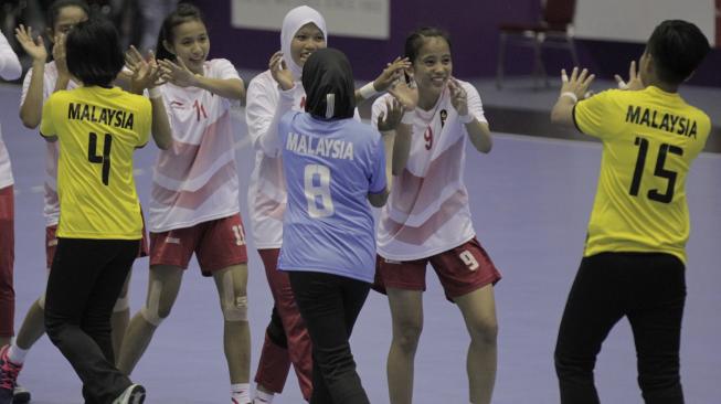 Pemain bola tangan Indonesia menyalami para pemain Malaysia usai menangi pertandingan di babak penyisihan Grup B Asian Games 2018, di GOR POPKI, Cibubur, Jakarta, Selasa (14/8). [INASGOC/Ridhwan Siregar]