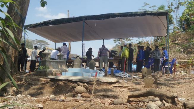 Makam yang berada persis di tengah Jalan Tol Trans Jawa yang sempat viral di media-media sosial saat arus mudik-balik Idul Fitri 2018, akhirnya dibongkar dan direlokasi ke tempat baru, Rabu (15/8/2018). [Suara.com/Adam Iyasa]