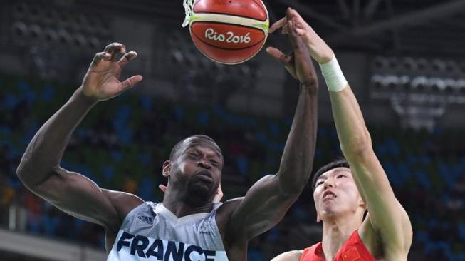 Center tim basket Cina, Zhou Qi (kanan), menepis bola dari tangan pebasket Prancis, Charles Kahudi, saat kedua negara bertemu di babak penyisihan Grup A Olimpiade 2016 Rio de Janeiro. [AFP/Andrej Isakovic]