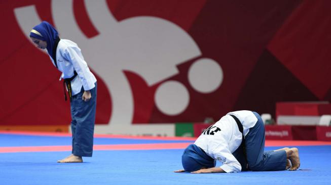 Taekwondoin putri Indonesia Rosmaniar Defia bersujud usai dinyatakan menang dari atlet Taekwondo putri Iran Marjan Salahshouri pada partai final Poomsae tunggal putri pada Asian Games 2018 di Jakarta Convention Center (JCC). Defia memperoleh medali emas untuk Indonesia. Minggu (19/8). ANTARA FOTO/INASGOC/ Darmawan