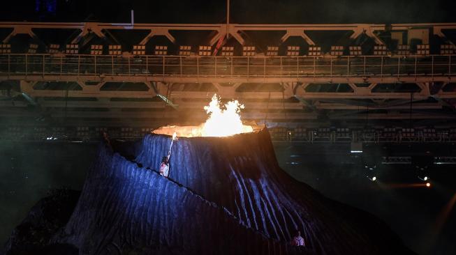 Mantan pebulu tangkis nasional Susi Susanti menyalakan api kualdron saat Pembukaan Asian Games ke-18 Tahun 2018 di Stadion Utama GBK, Jakarta, Sabtu (18/8). PGN akan menyalurkan gas bumi untuk kuladron di dalam dan luar stadion GBK dalam bentuk Compressed Natural Gas (CNG) yang merupakan bentuk dukungan PGN untuk menyukseskan ajang olahraga terbesar Asia itu yang berlangsung 18 Agustus-2 September 2018. ANTARA FOTO/Dhemas Reviyanto/pras/18.