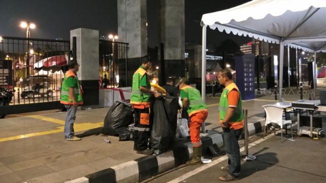 Petuga kebersihan saat bekerja seusai acara upacara Pembukaan Asian Games 2018, Sabtu (18/8/2018) malam. [Suara.com/Ria Rizki Nirmala Sari]