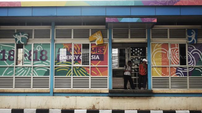 Warga menunggu Bus Transjakarta di Halte Busway, Jakarta, Senin (20/8). [Suara.com/Muhaimin A Untung]