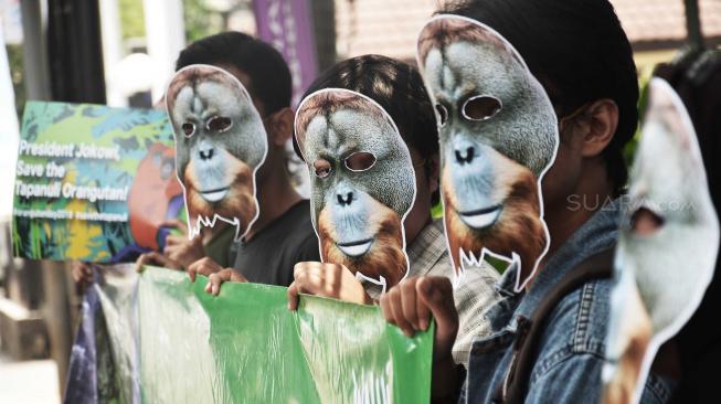 Sejumlah aktivis Wahana Lingkungan Hidup Indonesia (WALHI) memakai topeng Orang Utan Tapanuli saat aksi di depan Kantor PLN Pembangkit Jawa-Bali (PJB), Jakarta, Senin (20/8). [Suara.com/Muhaimin A Untung]