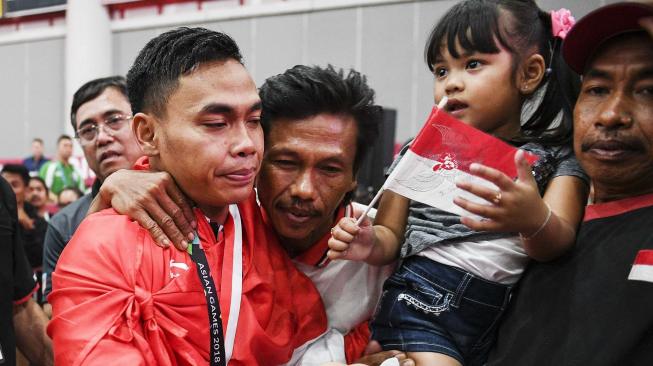 Lifter Indonesia Eko Yuli Irawan mendapat ucapan selamat dari keluarga seusai bertanding pada nomor angkat besi putra 62 kg Asian Games ke-18 2018 di JiExpo, Jakarta, Selasa (21/8). ANTARA FOTO/INASGOC/Dhemas Reviyanto