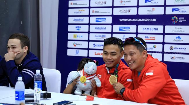 Lifter Indonesia, Eko Yuli Irawan, didampingi Manajer Tim Angkat Besi Indonesia, Dirdja Wihardja (kanan), dalam konferensi pers usai meraih medali emas cabang olahraga angkat besi kelas 62 kg putra Asian Games 2018 di Hall A JIExpo, Kemayoran, Jakarta, Selasa (21/8). [Suara.com/Dendi Afriyan]