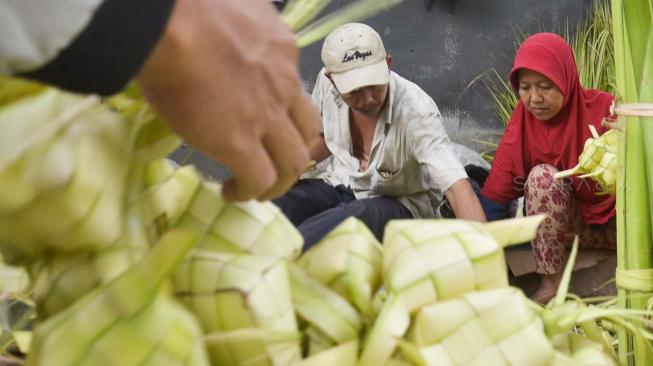 Pedagang kulit ketupat menata barang dagangannya di Pasar Ciracas, Jakarta, Selasa (21/8). Jelang hari raya Idul Adha, pedagang kulit ketupat dadakan mulai bermunculan. Pedagang sengaja menjual kulit ketupat menjelang lebaran karena tergiur keuntungan yang cukup besar. [Suara.com/Muhaimin A Untung]