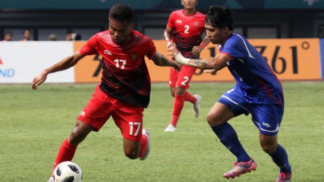 Pesepak bola Indonesia Saddil Ramdani (kiri) berebut bola dengan pesepak bola Chinese Taipei pada pertandingan Grup A Asian Games ke-18 di Stadion Patriot, Bekasi Minggu (12/8). Antara Foto/INASGOC/Ary Kristianto