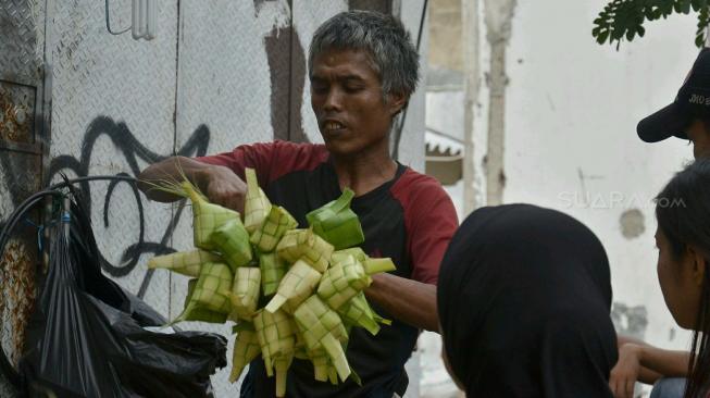 Pedagang kulit ketupat menata barang dagangannya di Pasar Ciracas, Jakarta, Selasa (21/8). Jelang hari raya Idul Adha, pedagang kulit ketupat dadakan mulai bermunculan. Pedagang sengaja menjual kulit ketupat menjelang lebaran karena tergiur keuntungan yang cukup besar. [Suara.com/Muhaimin A Untung]