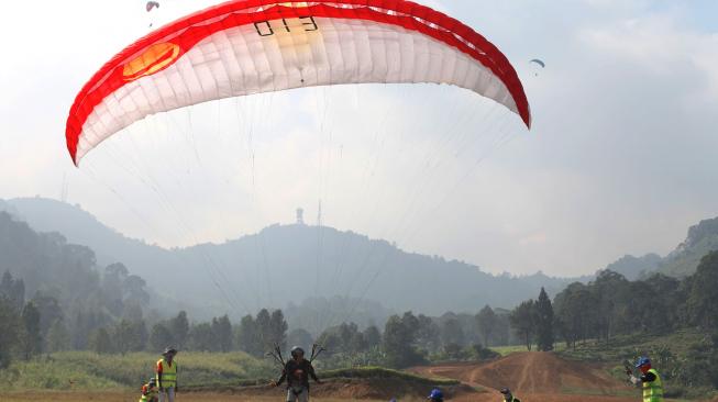 Penerbang Paralayang putra Indonesia Hening Paradigma menginjak target saat mendarat dalam babak ketiga ketepatan mendarat Asian Games 2018 di Gunung Mas Puncak, Bogor, Jawa Barat (21/8). ANTARA FOTO/INASGOC