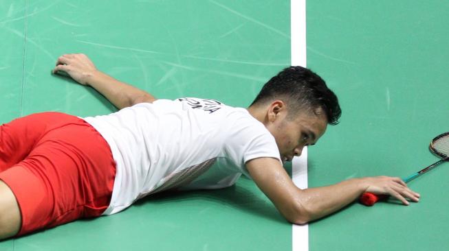 Pebulutangkis tunggal putra Indonesia, Anthony Sinisuka Ginting, tergeletak karena cedera saat mengawali final beregu putra Asian Games 2018. [Humas PBSI]