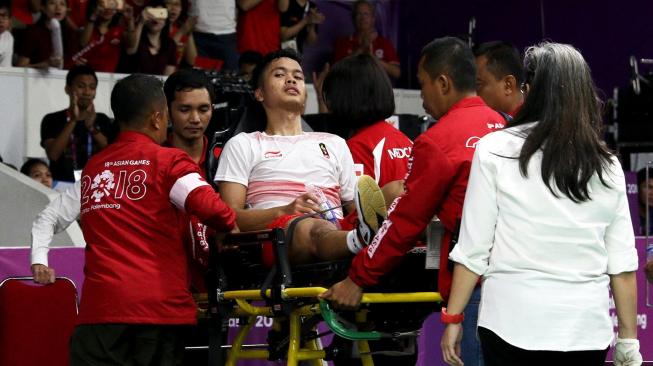 Pebulutangkis tunggal putra Indonesia, Anthony Sinisuka Ginting, ditandu keluar lapangan akibat cedera saat melawan wakil Cina, Shi Yuqi, dalam final bulutangkis beregu putra Asian Games 2018 di Istora Senayan, Jakarta, Rabu (22/8). [Humas PBSI]