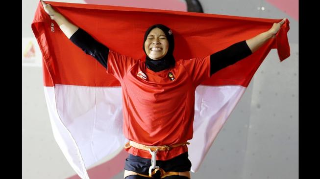 Atlet panjat tebing Indonesia, Aries Susanti Rahayu, melakukan selebrasi setelah memenangi final kategori speed putri Asian Games 2018 di Arena Panjat Tebing Jakabaring Sport City (JSC), Palembang, Kamis (23/8/2018). [Antara/INASGOC/Hendra Nurdiyansyah]