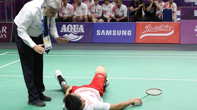 Pebulutangkis tunggal putra Indonesia, Anthony Sinisuka Ginting, alami cedera saat melawan wakil Cina, Shi Yuqi, dalam final bulutangkis beregu putra Asian Games 2018 di Istora Senayan, Jakarta, Rabu (22/8). [Humas PBSI]