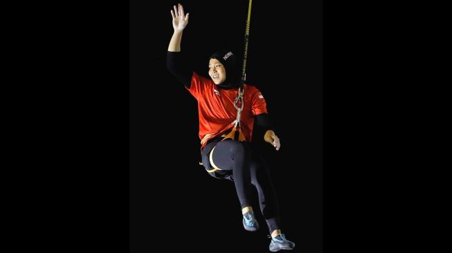 Atlet panjat tebing Indonesia, Aries Susanti Rahayu, melambaikan tangan setelah memenangi final kategori speed putri Asian Games 2018 di Arena Panjat Tebing Jakabaring Sport City (JSC), Palembang, Kamis (23/8/2018). [Antara/INASGOC/Iwan Cheristian]