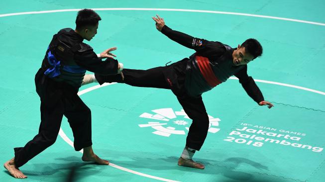 Pesilat Indonesia Abdul Malik (kanan) bertanding melawan pesilat Vietnam Dinh Tuan Nguyen (kiri) dalam babak 16 besar Kelas B Putra Asian Games 2018 di Padepokan Pencak Silat Taman Mini Indonesia Indah (TMII), Jakarta, Kamis (23/8). ANTARA FOTO/INASGOC/Melvinas Priananda