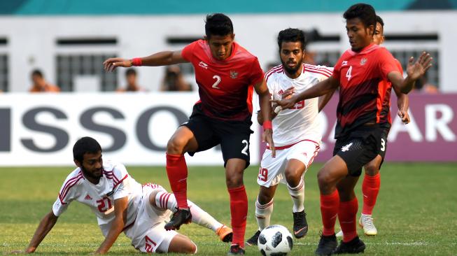 Pesepak bola Indonesia I Putu Gede (kedua kiri) mempertahankan bola dari pesepak bola Uni Emirat Arab Zayed Alameri (kiri) pada pertandingan Babak16 besar Asian Games ke 18 di Stadion Wibawa Mukti, Cikarang, Jawa Barat, Jum'at (24/8). ANTARA FOTO/INASGOC/Arif Nugroho