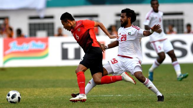 Pesepak bola Indonesia Evan Dimas (kiri) coba melewati hadangan pesepak bola Uni Emirat Arab Rashed Musabbah saat pertandingan Babak16 besar Asian Games ke 18 di Stadion Wibawa Mukti, Cikarang, Jawa Barat, Jum'at (24/8). ANTARA FOTO/INASGOC/Arif Nugroho