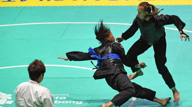 Pesilat Indonesia Wewey Wita (kanan) bertanding melawan pesilat Thailand Suda Lueangaphichatkun (kedua kanan) dalam babak perempat final Kelas B Putri Asian Games 2018 di Padepokan Pencak Silat Taman Mini Indonesia Indah (TMII), Jakarta, Jumat (24/8). ANTARA FOTO/INASGOC/Melvinas Priananda