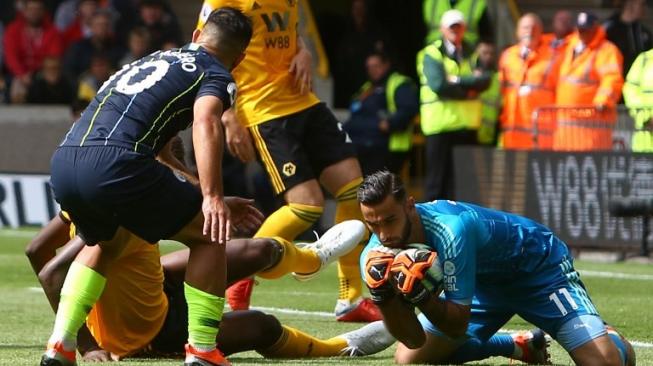 Penjaga gawang Wolverhampton Rui Patricio menggagalkan peluang pemain Man City Sergio Aguero  dalam pertandingan yang berlangsung di Molineux Stadium, Sabtu (25/8/2018) [AFP]