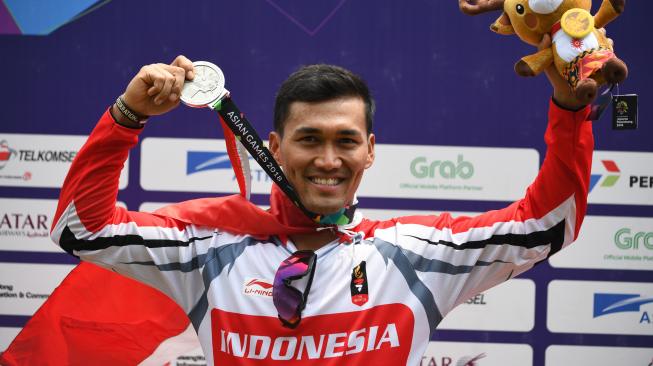 Atlet sepeda BMX Indonesia I Gusti Bagus Saputra menunjukan medali perak pada nomor Sepeda BMX Putra Asian Games ke-18 Tahun 2018 di Pulomas International BMX Center, Jakarta, Sabtu (25/8). ANTARA FOTO/INASGOC/Mohammad Ayudha