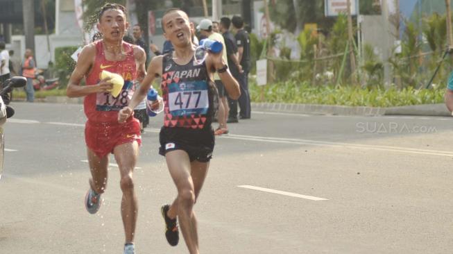 Para pelari saat tampil pada nomor marathon putra Asian Games 2018 di jalan Jendral Sudirman Jakarta, Sabtu (25/8). [Suara.com/Muhaimin A Untung]