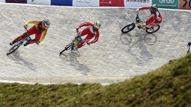 Pebalap sepeda BMX perempuan China Yan Lu (kiri), pebalap Indonesia Wiji Lestari (tengah) dan Cupi Nipianti memacu sepedanya saat babak kualifikasi Asian Games ke-18 Tahun 2018 di Pulo Mas International, Jakarta, Sabtu (25/8). ANTARA FOTO/INASGOC/Jefri Tarigan