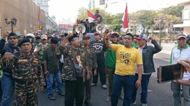 Ratusan massa menolak Ahmad Dhani yang akan melakukan aksi deklarasi ganti presiden di Surabaya, Minggu (26/8/2018) . (Dimas Angga Perkasa/Suara.com)