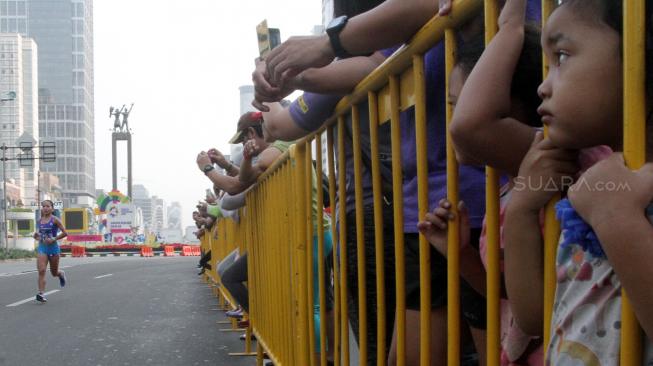 Meski tidak ada  Car Free Day (CFD) warga Jakarta tetap datang untuk menyaksikan lari marathon dan terlihat begitu antusias meskipun mereka hanya menyaksikan dari bahu jalan. [Suara.com/Oke Dwi Atmja]