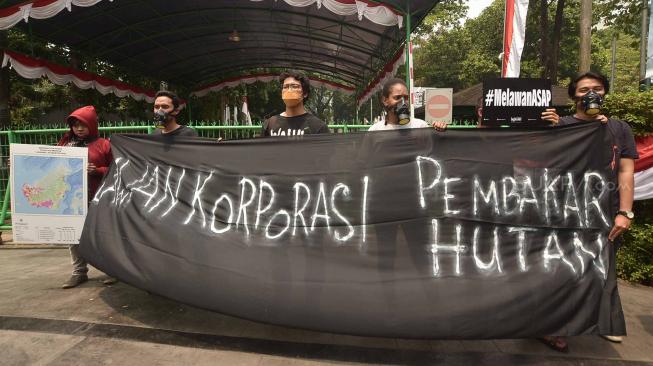 Sejumlah aktivis Wahana Lingkungan Hidup Indonesia (WALHI) memakai masker saat aksi protes pembakaran hutan di depan Kantor Kementerian Lingkungan Hidup dan Kehutanan (KLHK), Jakarta, Senin (27/8). [Suara.com/Muhaimin A Untung]