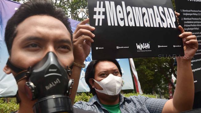 Sejumlah aktivis Wahana Lingkungan Hidup Indonesia (WALHI) memakai masker saat aksi protes pembakaran hutan di depan Kantor Kementerian Lingkungan Hidup dan Kehutanan (KLHK), Jakarta, Senin (27/8). [Suara.com/Muhaimin A Untung]