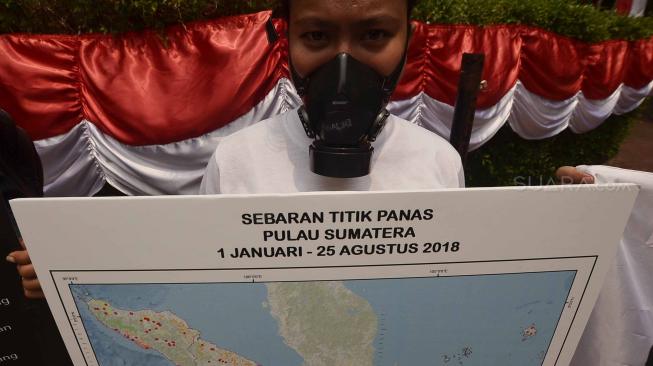 Sejumlah aktivis Wahana Lingkungan Hidup Indonesia (WALHI) memakai masker saat aksi protes pembakaran hutan di depan Kantor Kementerian Lingkungan Hidup dan Kehutanan (KLHK), Jakarta, Senin (27/8). [Suara.com/Muhaimin A Untung]