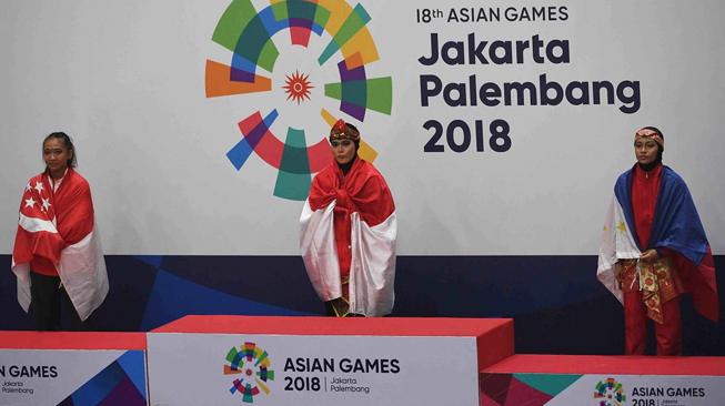 Pesilat Indonesia peraih medali emas Puspa Arumsari (tengah) bersiap bersama pesilat Singapura peraih medali perak Nurzuhairah Mohammad Yazid (kiri) dan pesilat Filipina peraih perunggu Cherry May Regalado (kanan) untuk mengikuti upacara penyerahan medali nomor tunggal putri pencak silat seni Asian Games 2018 di Padepokan Pencak Silat Taman Mini Indonesia Indah (TMII), Jakarta, Senin (27/8). ANTARA FOTO/INASGOC/Melvinas Priananda