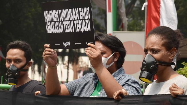 Sejumlah aktivis Wahana Lingkungan Hidup Indonesia (WALHI) memakai masker saat aksi protes pembakaran hutan di depan Kantor Kementerian Lingkungan Hidup dan Kehutanan (KLHK), Jakarta, Senin (27/8). [Suara.com/Muhaimin A Untung]