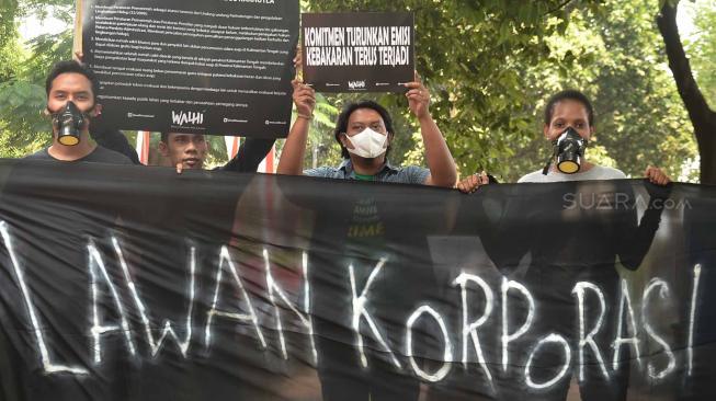 Sejumlah aktivis Wahana Lingkungan Hidup Indonesia (WALHI) memakai masker saat aksi protes pembakaran hutan di depan Kantor Kementerian Lingkungan Hidup dan Kehutanan (KLHK), Jakarta, Senin (27/8). [Suara.com/Muhaimin A Untung]