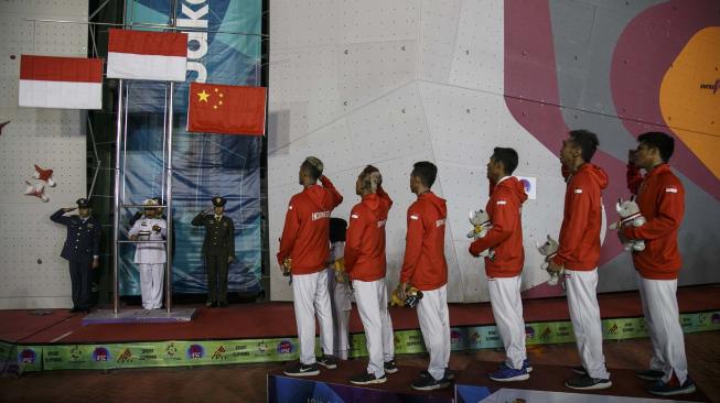 Regu panjat tebing Indonesia melakukan penghormatan kepada bendera merah putih setelah menang pada final speed relay putra Asian Games 2018 di Arena Panjat Tebing Jakabaring Sport City, Palembang, Sumatera Selatan, Senin (27/8). ANTARA FOTO/INASGOC/Hendra Nurdiyansyah