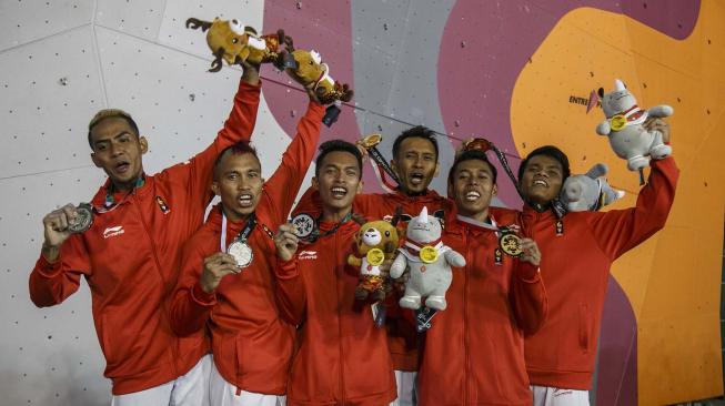 Regu panjat tebing Indonesia menunjukkan medali setelah menang pada final speed relay putra Asian Games 2018 di Arena Panjat Tebing Jakabaring Sport City, Palembang, Sumatera Selatan, Senin (27/8). ANTARA FOTO/INASGOC/Hendra Nurdiyansyah