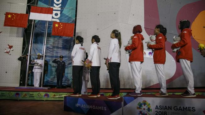 Regu panjat tebing Indonesia dan Cina mengikuti upacara penganugerahan medali seusai final speed relay putri Asian Games 2018 di Arena Panjat Tebing Jakabaring Sport City, Palembang, Sumatera Selatan, Senin (27/8). ANTARA FOTO/INASGOC/Hendra Nurdiyansyah