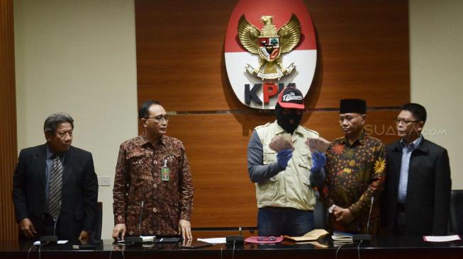 Penyidik memperlihatkan barang bukti ott bersama Ketua KPK Agus Rahardjo, Wakil Ketua Mahkamah Konstitusi Bidang Non Yudisial Sunarto, Kepala Biro Humas MA Abdullah, dan Juru Bicara Mahkamah Agung Suhadi bersiap memberikan keterangan pers di Gedung KPK, Jakarta, Rabu (28/8). [Suara.com/Muhaimin A Untung] 