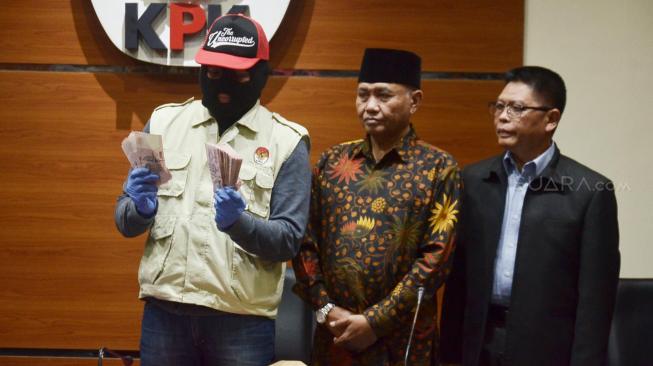 Penyidik memperlihatkan barang bukti disaksikan Ketua KPK Agus Rahardjo dan Kepala Biro Humas MA Abdullah memberikan keterangan pers di Gedung KPK, Jakarta, Rabu (28/8). [Suara.com/Muhaimin A Untung] 