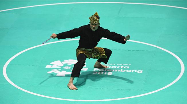 Pesilat Indonesia Sugianto tampil dalam babak final tunggal putra pencak silat seni Asian Games 2018 di Padepokan Pencak Silat Taman Mini Indonesia Indah (TMII), Jakarta, Rabu (29/8). ANTARA FOTO/INASGOC/Melvinas Priananda