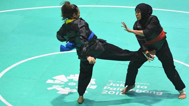 Pesilat Indonesia Pipiet Kamelia (belakang) menahan serangan pesilat Vietnam Thi Cam Nhi Nguyen (depan) dalam babak final Kelas D Putri Asian Games 2018 di Padepokan Pencak Silat Taman Mini Indonesia Indah (TMII), Jakarta, Rabu (29/8). ANTARA FOTO/INASGOC/Melvinas Priananda