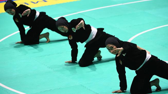 Tim silat Indonesia, Pramudita Yuristya (kiri), Lutfi Nurhasanah (tengah) dan Gina Tri Lestari (kanan) tampil dalam babak final beregu putri pencak silat seni Asian Games 2018 di Padepokan Pencak Silat Taman Mini Indonesia Indah (TMII), Jakarta, Rabu (29/8). ANTARA FOTO/INASGOC/Melvinas Priananda