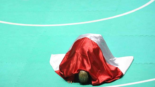 Ekspresi pesilat Indonesia Hanifah Yudani Kusumah usai mengalahkan pesilat Vietnam Thai Linh Nguyen dalam babak final Kelas C Putra Asian Games 2018 di Padepokan Pencak Silat Taman Mini Indonesia Indah (TMII), Jakarta, Rabu (29/8). ANTARA FOTO/INASGOC/Melvinas Priananda