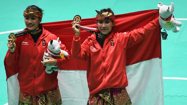 Pasangan pesilat Indonesia peraih medali emas Ayu Sidan Wilantari (kiri) dan Ni Made Dwiyanti (kanan) berpose usai upacara penyerahan medali nomor ganda putri pencak silat seni Asian Games 2018 di Padepokan Pencak Silat Taman Mini Indonesia Indah (TMII), Jakarta, Rabu (29/8). ANTARA FOTO/INASGOC/Melvinas Priananda