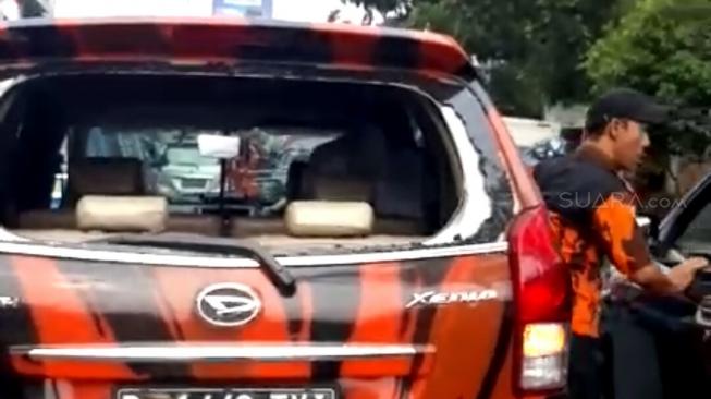 Satu unit mobil milik anggota ormas Pemuda Pancasila (PP) diduga dirusak aparat setelah bersitegang saat iring-iringan kendaraan polisi di Jalan Raya Puncak, Kabupaten Bogor, Jawa Barat. [suara.com/Putra Ramadhani]