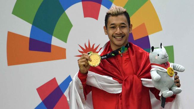 esilat Indonesia peraih medali emas Hanifah Yudani Kusumah berpose usai upacara penyerahan medali Kelas C Putra Asian Games 2018 di Padepokan Pencak Silat Taman Mini Indonesia Indah (TMII), Jakarta, Rabu (29/8). ANTARA FOTO/INASGOC/Melvinas Priananda