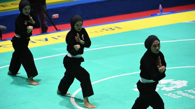 Tim silat Indonesia, Pramudita Yuristya (kiri), Lutfi Nurhasanah (tengah) dan Gina Tri Lestari (kanan) tampil dalam babak final beregu putri pencak silat seni Asian Games 2018 di Padepokan Pencak Silat Taman Mini Indonesia Indah (TMII), Jakarta, Rabu (29/8). ANTARA FOTO/INASGOC/Melvinas Priananda