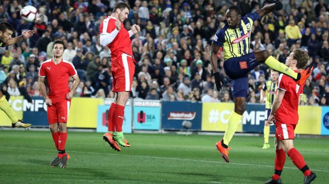 Penampilan mantan sprinter Usain Bolt dalam pertandingan sepak bola perdananya bersama klub Central Coast Mariners (CCM), melawan tim seleksi setempat di Gosford, New South Wales, Australia, Jumat (31/8/2018) malam. [Andrew Murray/AFP]