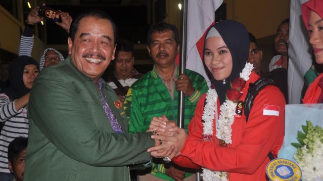 Kedatangan peraih medali emas Asian Games 2018, cabor pencak silat, Sarah Tria Monita, dan atlet lainnya  disambut Ketua Umum KONI Jatim, Erlangga Satriagung, dipintu kedatangan Bandara Internasional Juanda, Surabaya, Senin (3/9/2018) [Suara.com/Dimas Angga]